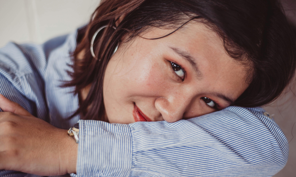 vrouw is zelf mindfulness aan het doen en kijkt tevreden
